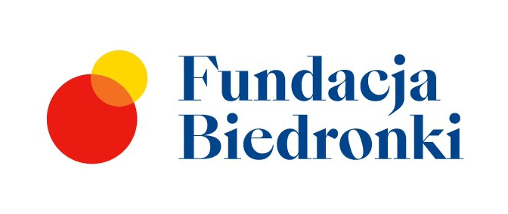 Logo Fundacja Biedronki, Granatowy napis na białym tle. Z lewej strony większe czerwone i mniejsze nachodzące na niego żółte koło. 