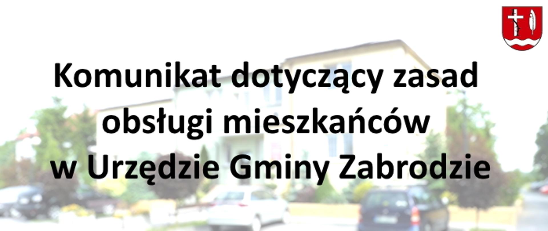 Na tle rozjaśnionego i rozmytego żółtego budynku tekst: Komunikat dotyczący zasad obsługi mieszkańców w Urzędzie Gminy Zabrodzie. W prawym górnym rogu czerwony herb gminy Zabrodzie z białym piórem, krzyżem oraz rzeką pod nimi
