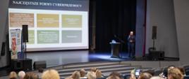 Uczestnicy konferencji w Centrum Kultury i Wypoczynku w Proszowicach podczas spotkania, na scenie jeden z prelegentów