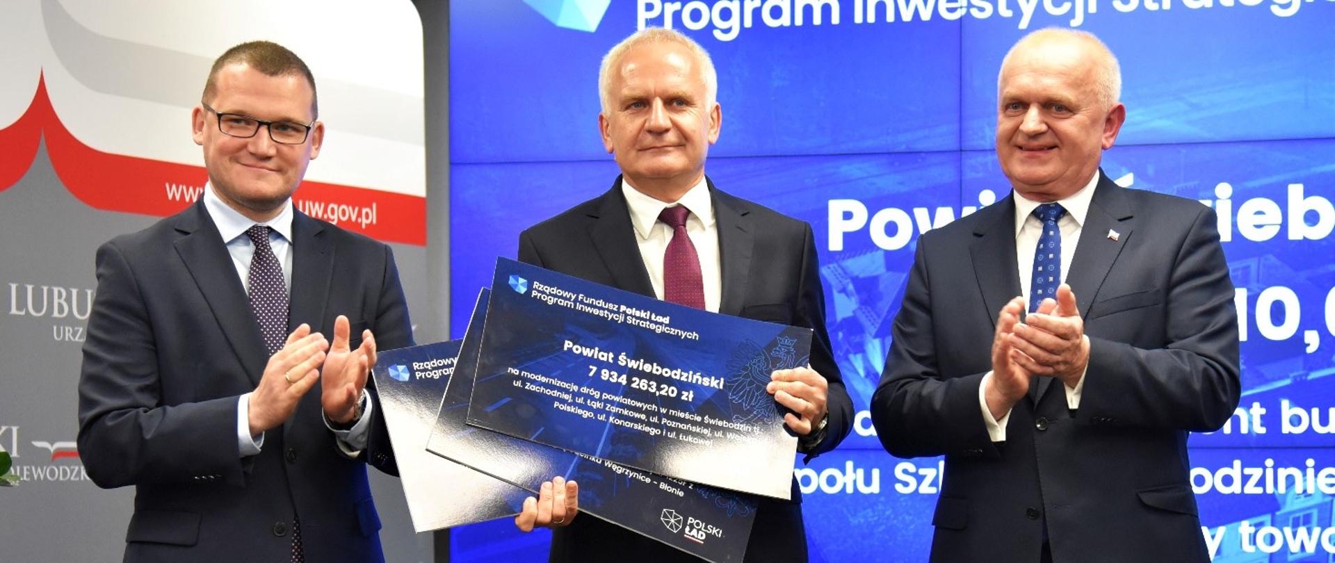 trzech mężczyzn w garniturach wewnątrz