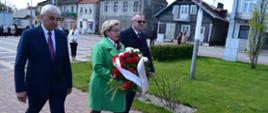 Od lewej; Zastępca Burmistrza Miasta i Gminy Mordy Leszek Konstańczuk, Radna Rady Miejskiej w Mordach Katarzyna Kotowska (trzyma w ręku wiązankę kwiatów) oraz Burmistrz Miasta i Gminy Mordy Jan Paweł Ługowski podczas ceremonii składania kwiatów pod Pomnikiem "Poległych 1918-1920" na Placuw centrum Miasta Mordy