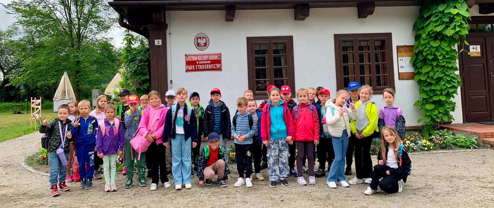 Uczniowie klas Ia i Ib stoją przed budynkiem Kultury Ludowej w Kolbuszowej