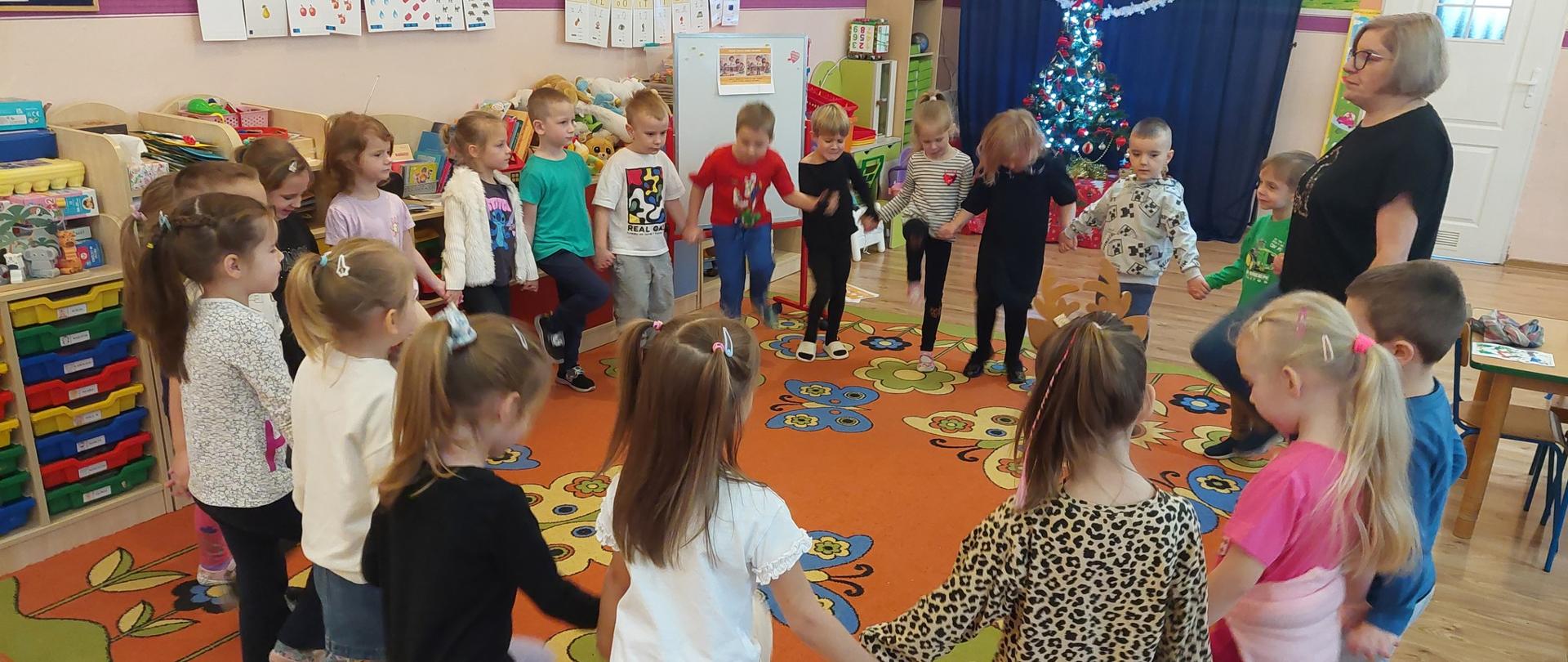 1 kobieta i grupa dzieci ustawionych w kole 