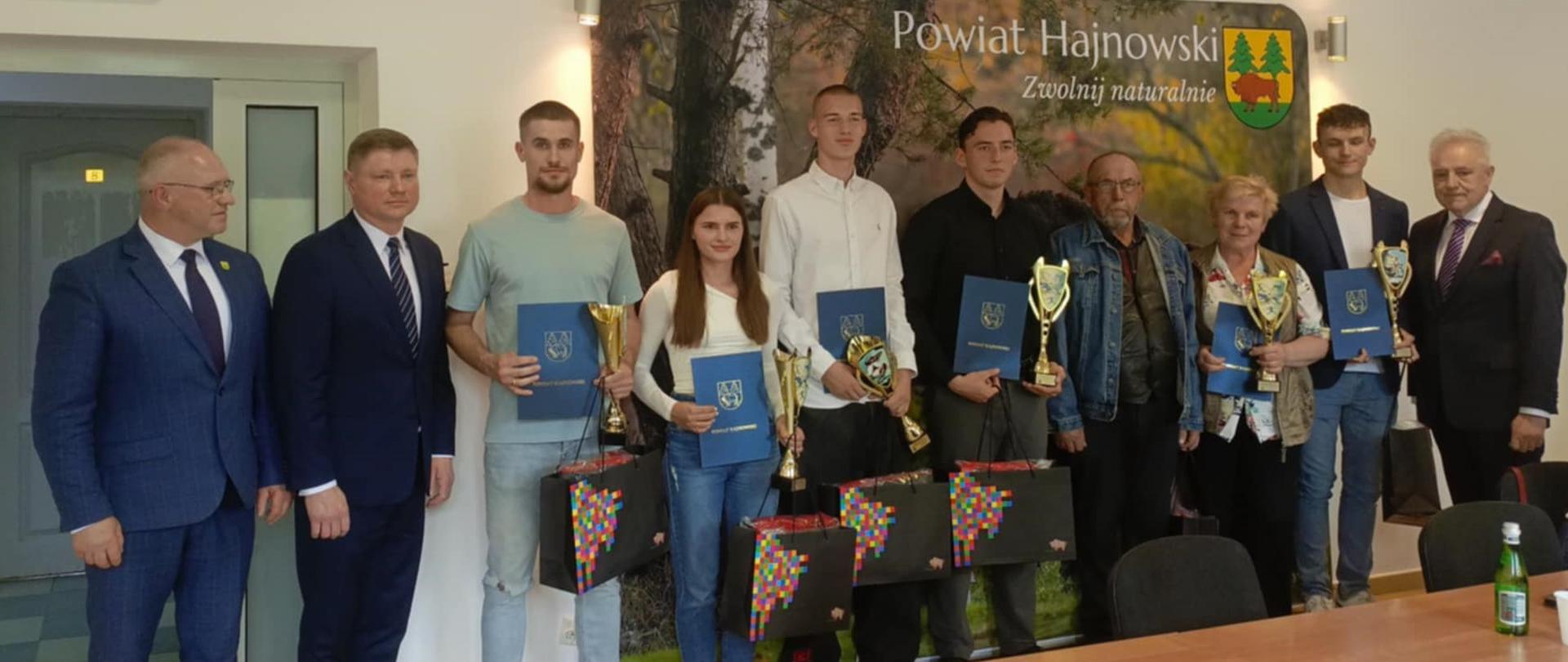 Nagrodzeni sportowcy wraz ze Starostą Hajnowskim, Wicemarszałkiem i Przewodniczącym Rady Powiatu pozują do zdjęcia