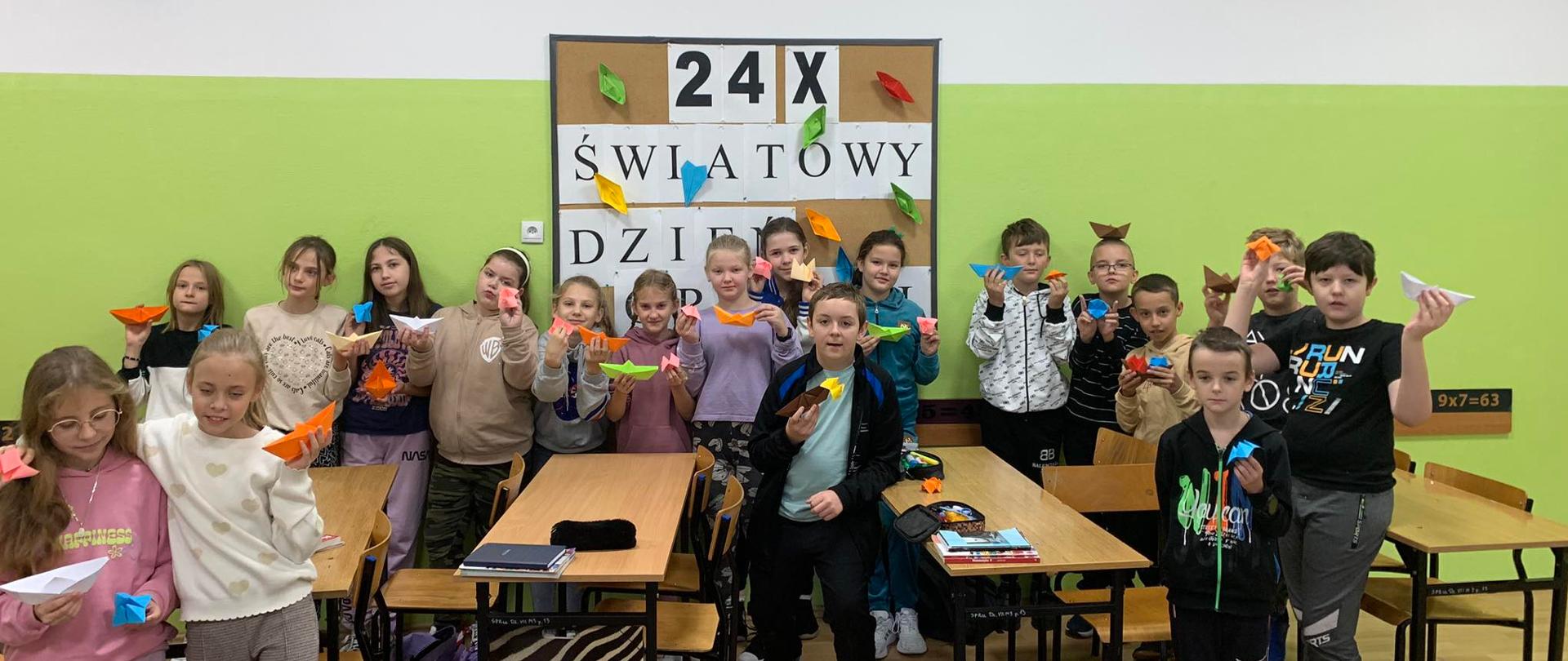 Dzieci z łódkami origami w klasie