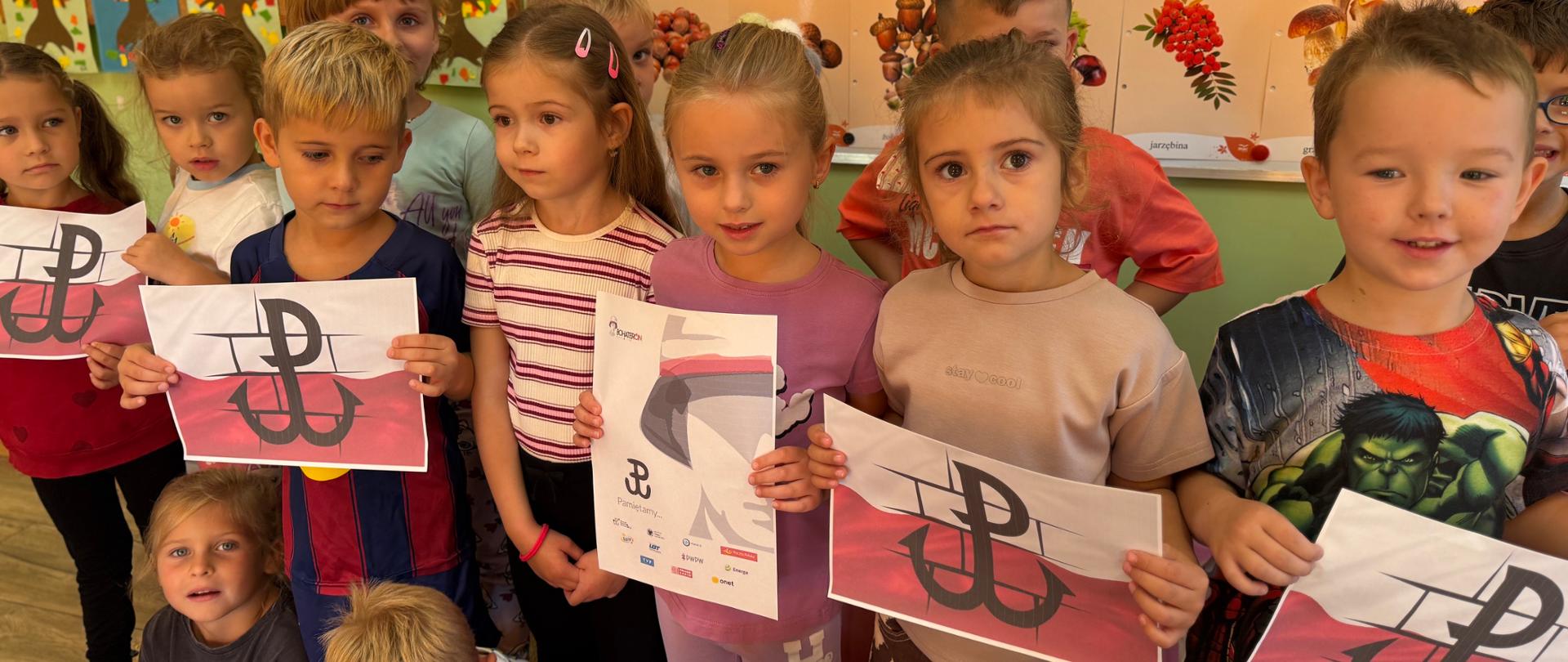 Grupa dzieci podczas pozuje do zdjęcia z plakatami w ramach ogólnopolskiej akcji BohaterON