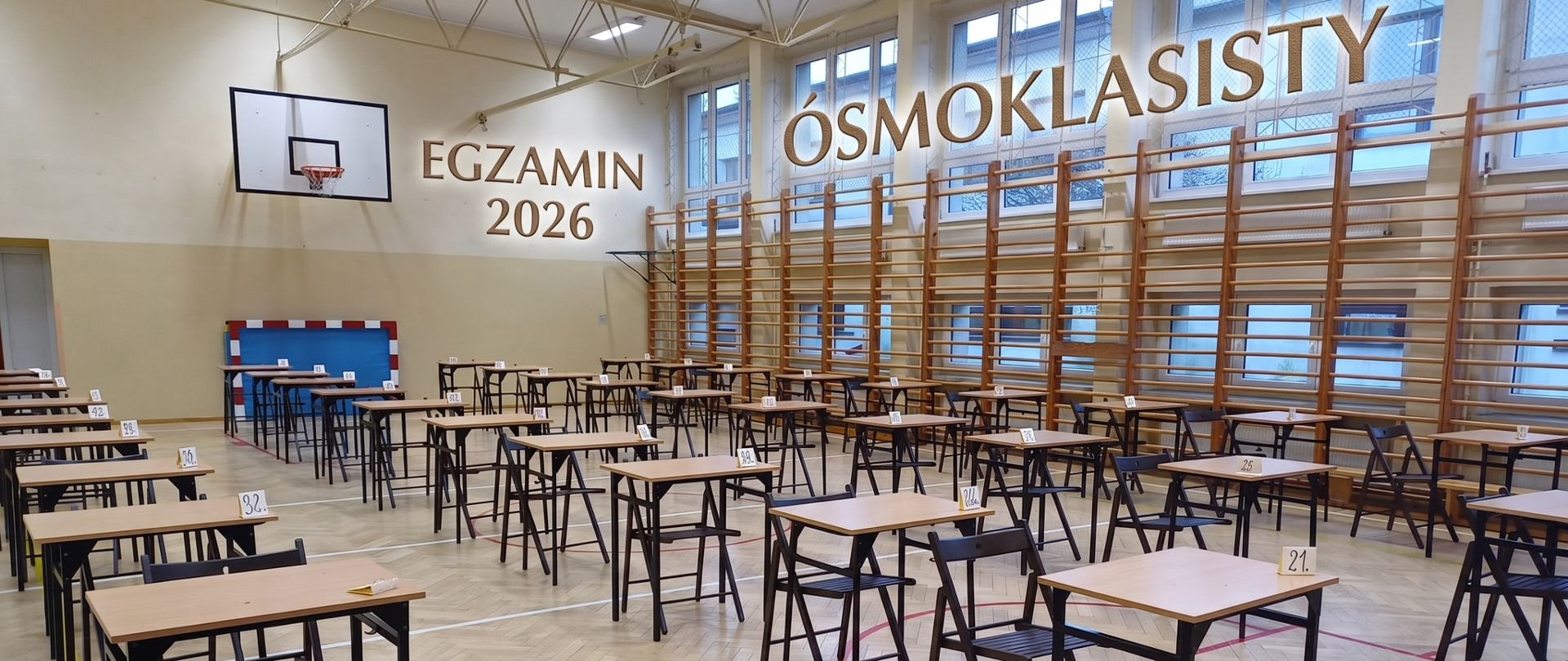 Sala gimnastyczna pełna stolików z krzesłami