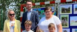 Odbiór nagród najmłodszych laureatów. Na zdjęciu trójka dzieci za nimi, Pani Zastępca Dyrektora Szkoły Podstawowej w Rokicinach Podhalańskich, przedstawiciel GOPSu Paweł Wojdyła oraz Sołtys Wsi Rokiciny Nina Gryglicka.