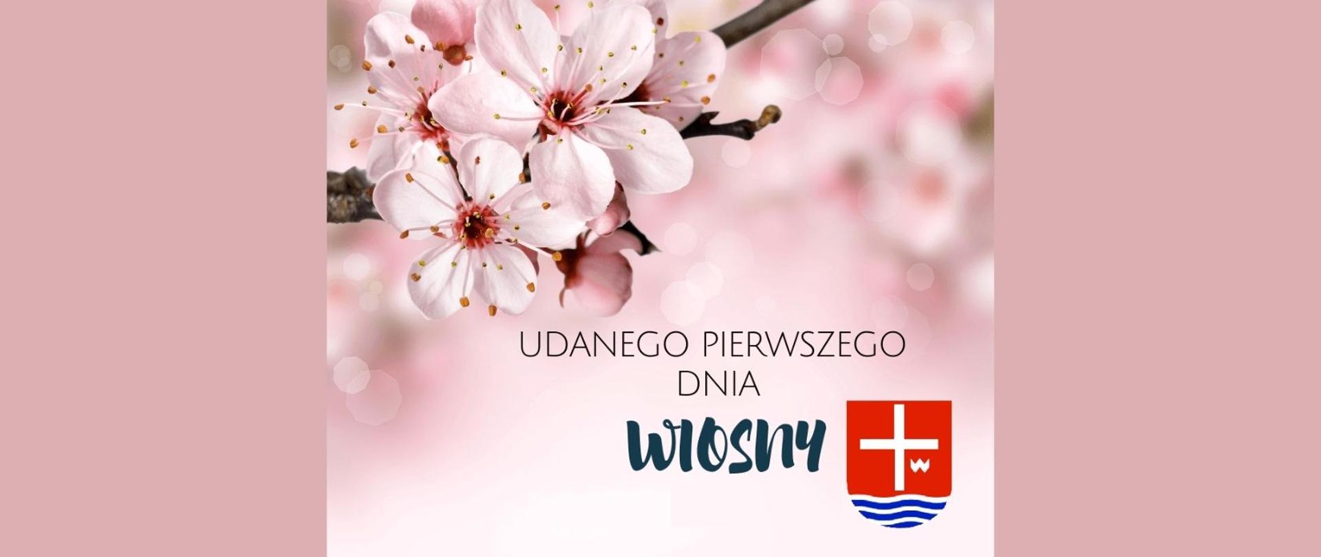 Napis, udanego pierwszego dnia wiosny z herbem powiatu na pudrowo różowym tle. W grafice znajdują się białe kwiaty drzewa owocowego.