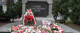 na zdjęciu znajduje się pomnik Powstania Styczniowego mieszczący się na Placu Sikorskiego w Zambrowie a przed nim leżą patriotyczne wiązanki kwiatów złożone przez zaproszone delegacje