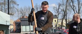 Na zdjęciu widoczny jest pan burmistrz, który miesza ogromną drewnianą łyżką żurek.