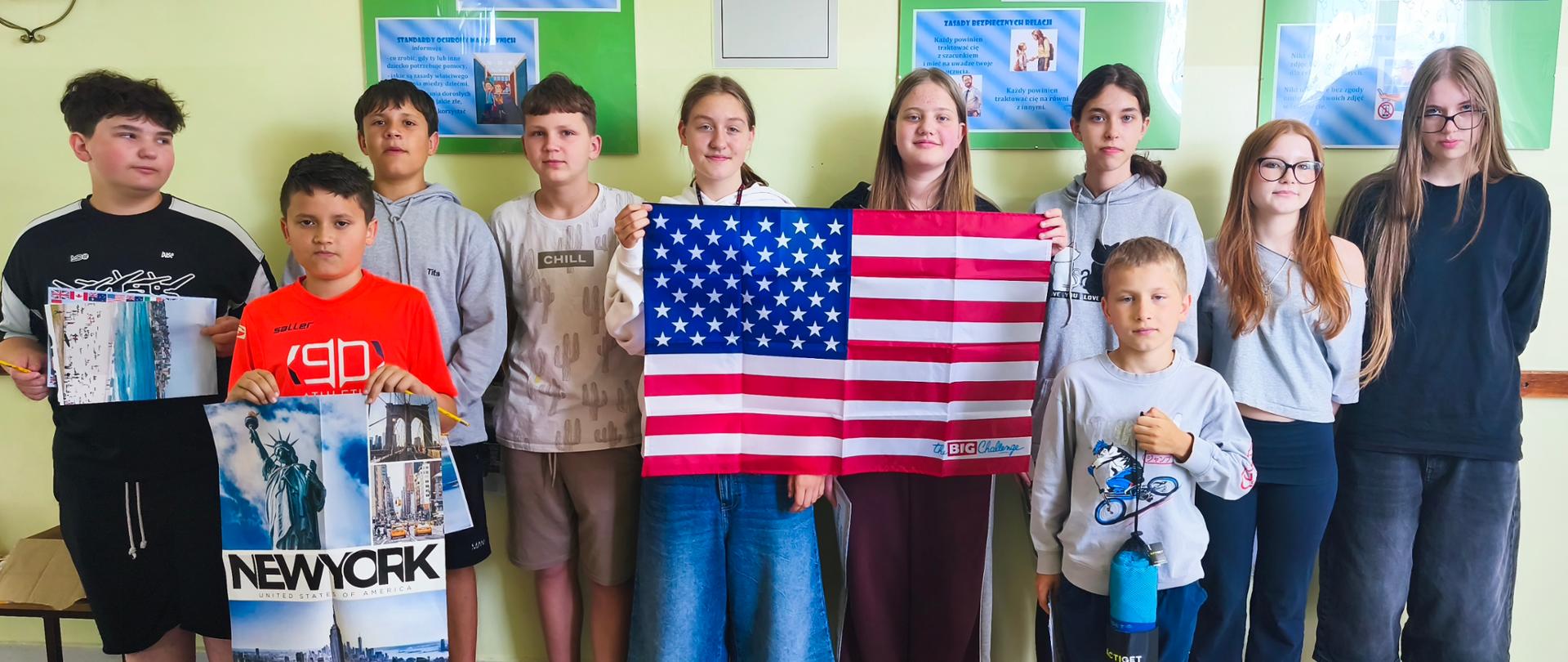 Uczniowie biorący udział w konkursie języka angielskiego „The Big Challenge” pozują z flagą Stanów Zjednoczonych