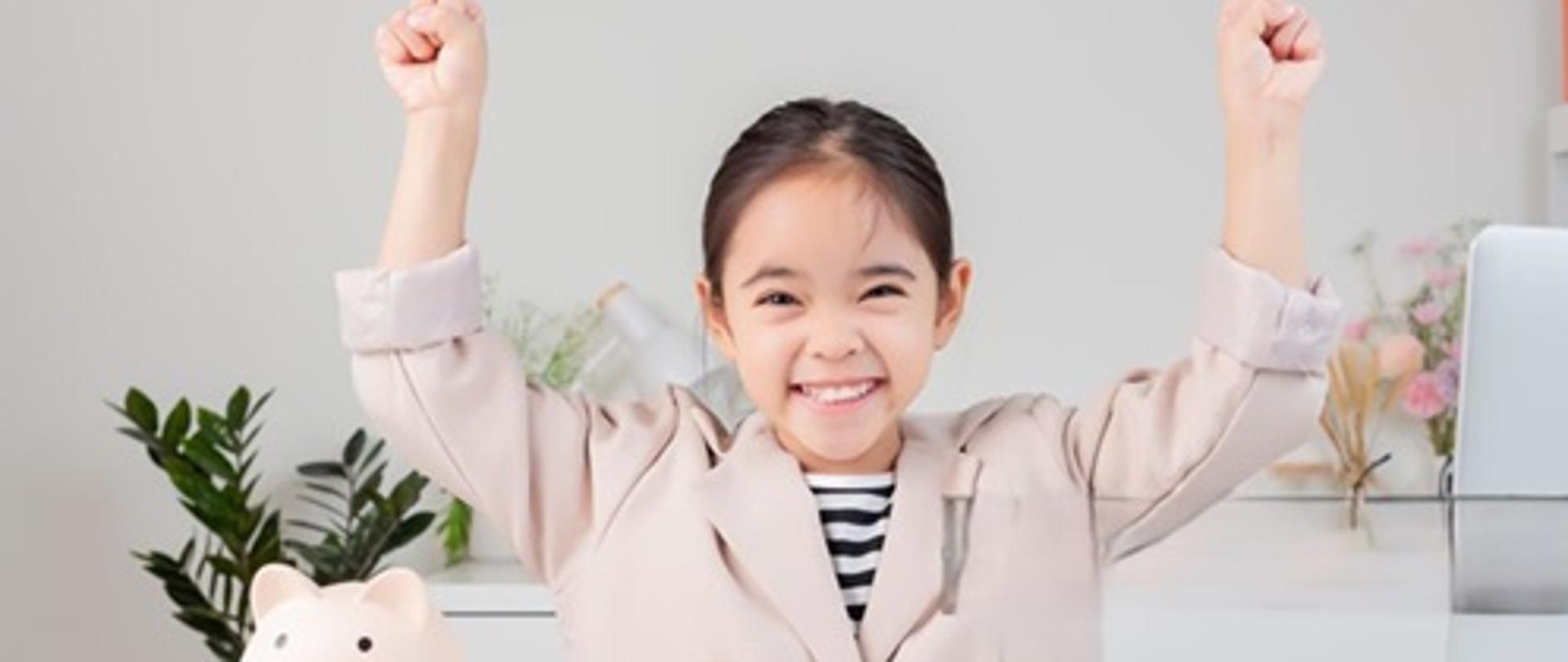 Asian little cute girl wearing a cream suit analyzing coins concept of finance and investment in white room