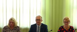 Skarbnik Powaitu Proszowickiego przedstawia projekt uchwały, obok Starosta i Wicestarosta Powiatu Proszowickiego
