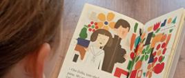 Kolorowe ilustracje w książce, którą trzyma w ręku uczennica