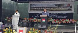 Na przystrojonej scenie przemawiają burmistrz Miasta i Gminy w Kosowie Lackim oraz dyrektorka przedszkola. W tle baner z wizerunkiem budynku.