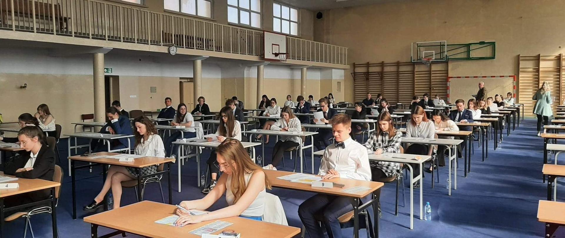 grupa osób przy biurkach wewnątrz