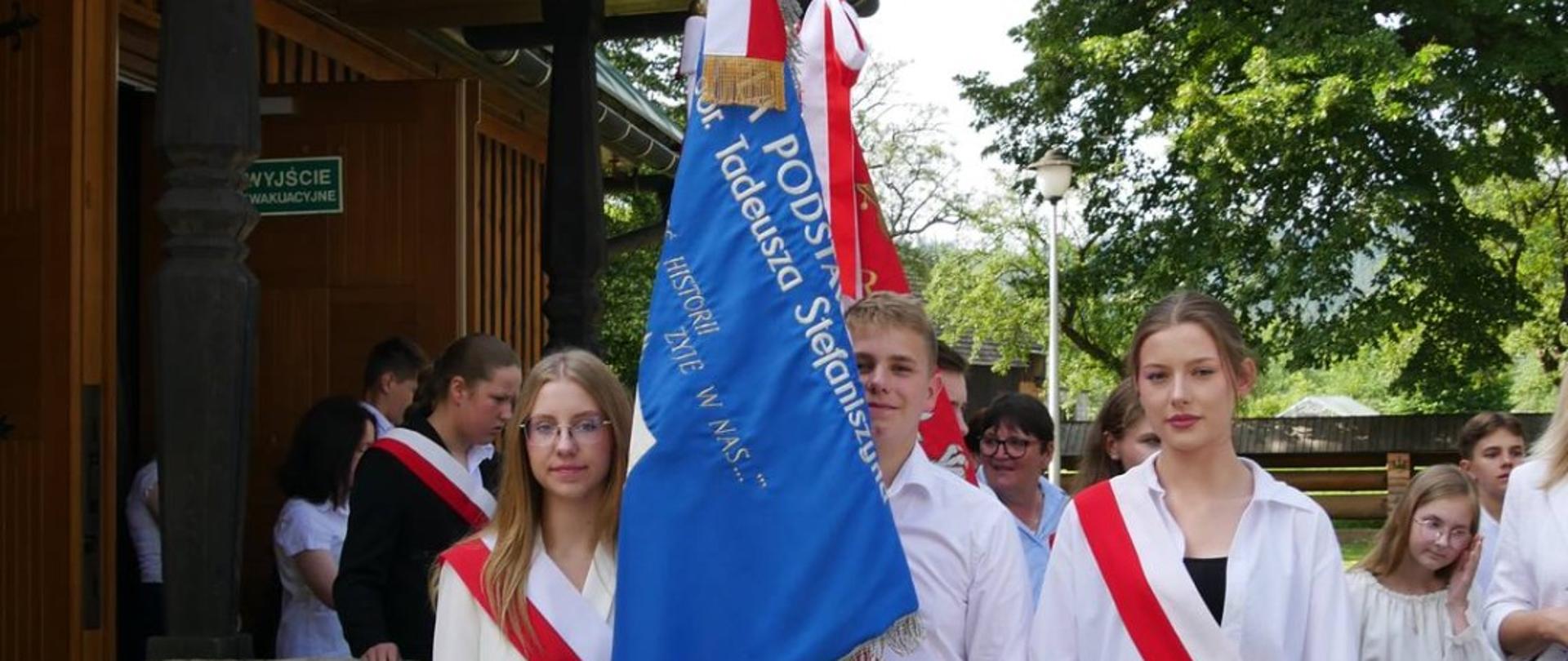 Uczniowie z pocztu sztandarowego przed kościołem NPNMP w Spytkowicach. 