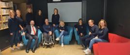 Zdjęcie wykonano w Bibliotece Miejskiej imienia Zofii Nałkowskiej w Przasnyszu. Fotografia przedstawia pozujących do wspólnego zdjęcia Starostę Powiatu Przasnyskiego siedzącego obok Dyrektor Biblioteki Małgorzaty Sobiesiak oraz pozostałych pracowników biblioteki.