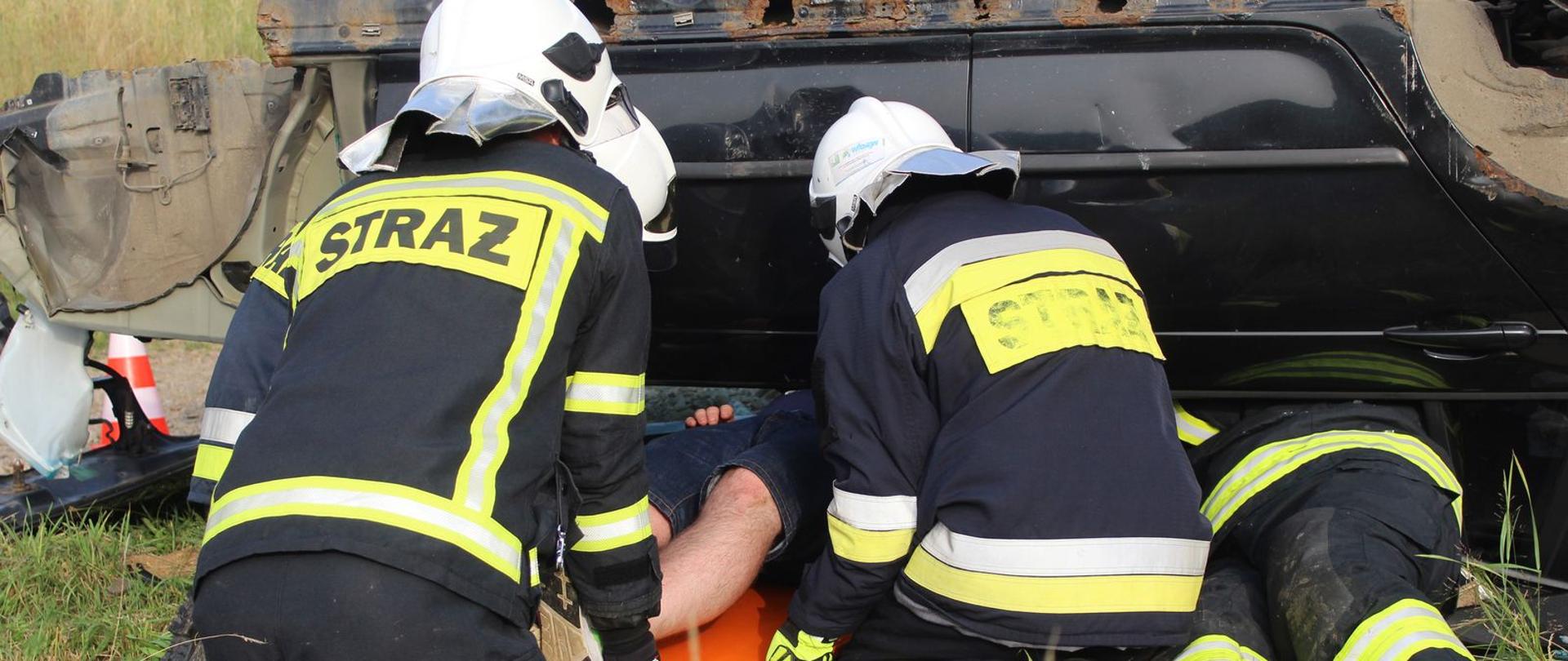 Akcja w ramach - Gminne ćwiczenia OSP Las 2021. Na zdjęciu strażacy ochotnicy wyciągający poszkodowanego z rozbitego samochodu. 