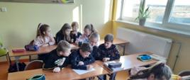 Dzieci siedzące w ławkach