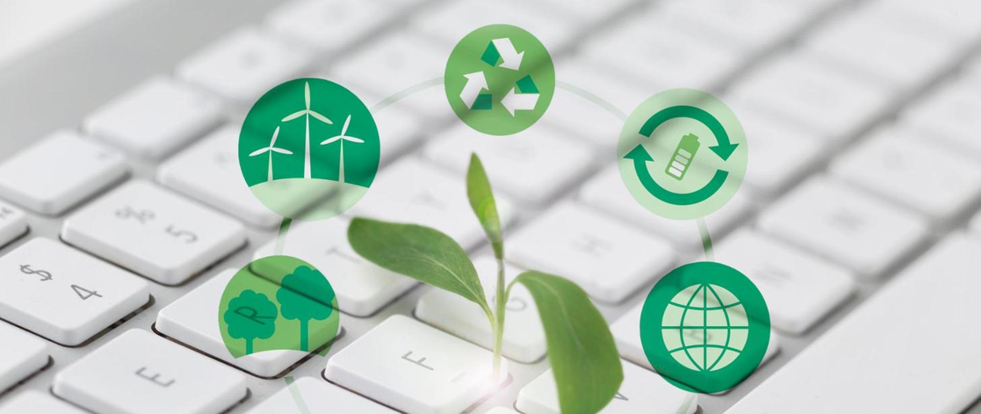 Zdjęcie klawiatury komputera nad nią zielone ikonki symbolizujące odnawialne źródła energii