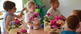 Grupa dzieci podczas warsztatów florystycznych z wykonanymi flowerboxami
