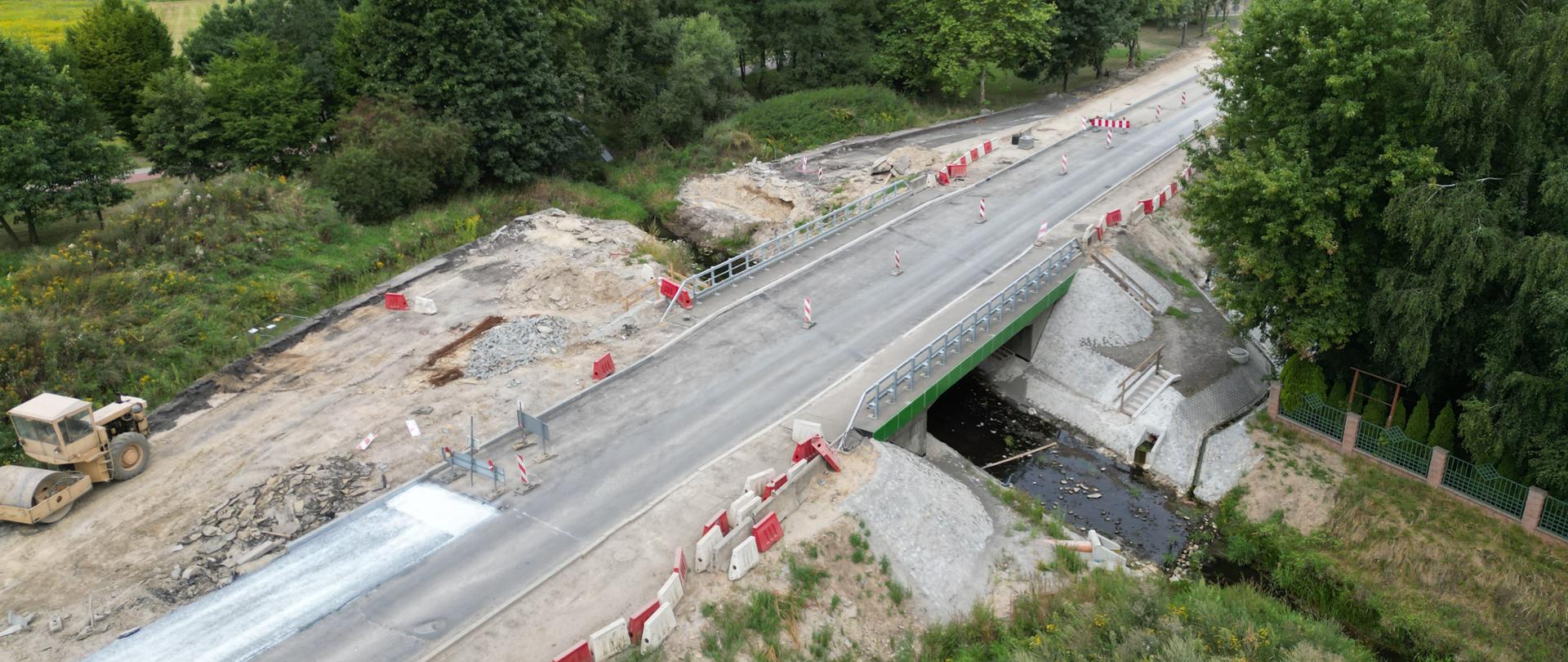 Most nad małą rzeką wokoło rosną drzewa