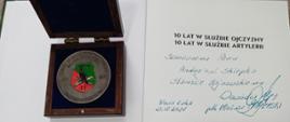 Pamiątkowy medal i książka z dedykacją przekazana Staroście Hajnowskiemu