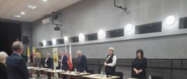W oddali - Gustaw Dmowski- Wiceprzewodniczący Rady Miejskiej w Mordach, Katarzyna Kotowska- Przewodnicząca Rady Miejskiej w Mordach, Jan Paweł Ługowski Burmistrz Miasta i Gminy Mordy (przemawia, za Nim widoczne dwie flagi Polski), Zastępca Burmistrza Miasta i Gminy Mordy Leszek Konstańczuk, Skarbnik Miasta i Gminy Mordy Monika Nasiłowska Osik, Skarbnik Miasta i Gminy Mordy Lidia Lipińska. Na zdjęciu widoczni także - Mirosław Leszek Romanowski - Radny Rady Miejskiej w Mordach oraz Grażyna drabarek- Radna Rady Miejskiej w Mordach.