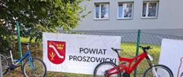 Baner Powiatu Proszowickiego podczas III Proszowickiego Triathlonu Lotników, obok rowery zawodników