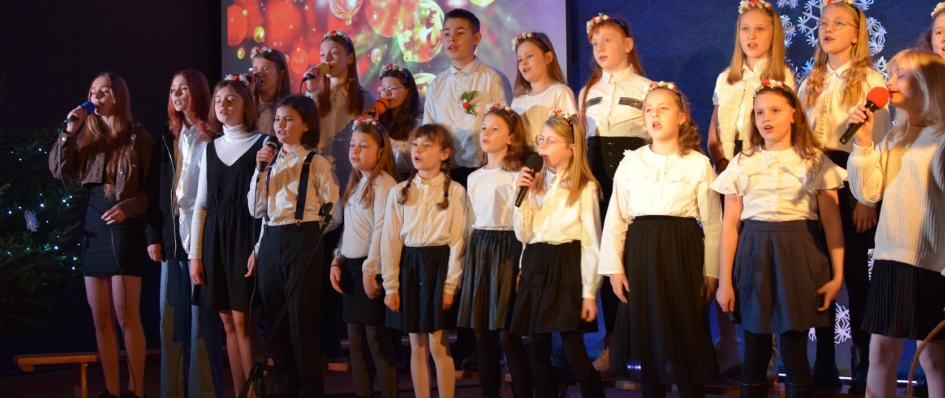 26 młodych artystów ze Studia Piosenki SP 1 na scenie śpiewa znane i lubiane polskie kolędy. 