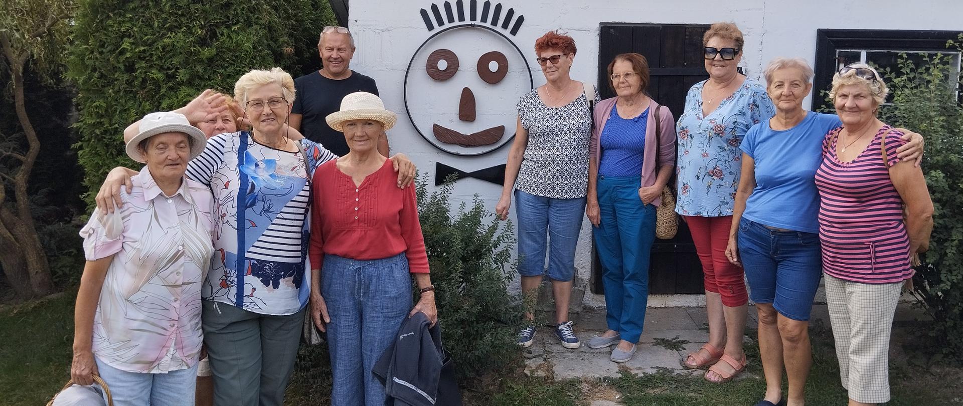 Członkowie Klubu Senior+ przed "małym muzeum staroci"