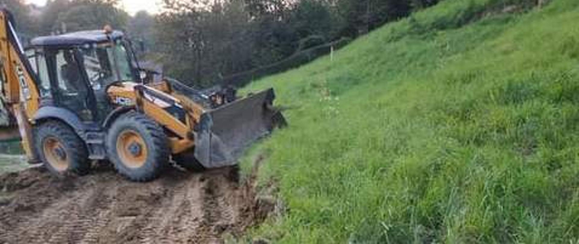 widoczna koparka JCB przy pracy po prawej skarpa