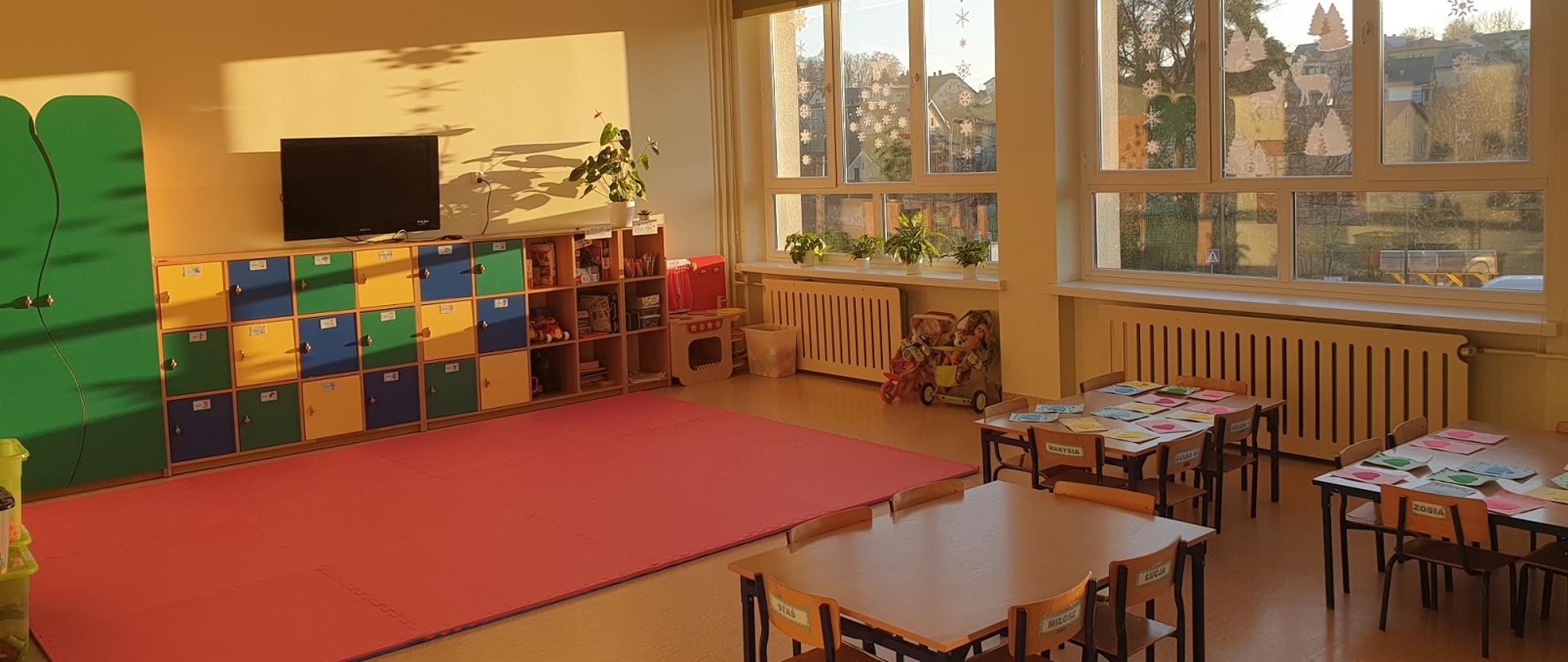 Jedna z dwóch nowych sal przedszkola w Zespole Szkolno-Przedszkolnym w Kończycach Wielkich. Stoją ławki i krzesła, na podłodze mata, z tyłu meble, z boku okno