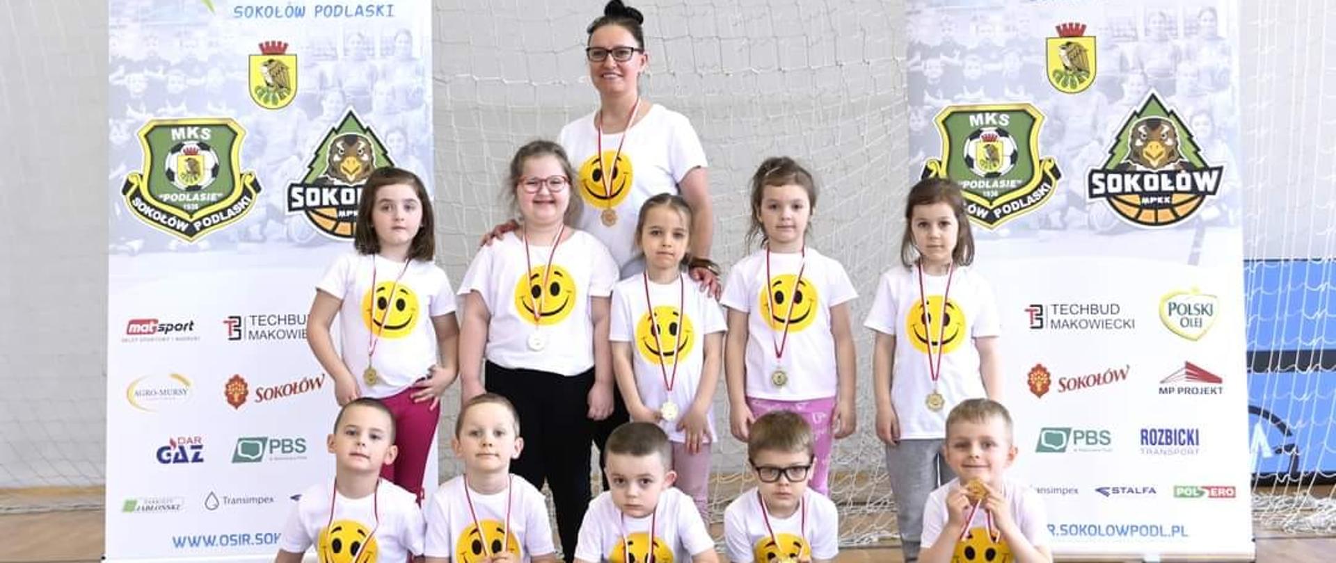 1 osoba dorosła i dzieci na sali sportowej
