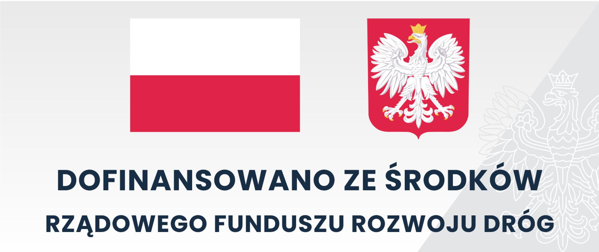 Szara tablica z flagą oraz godłem polskim z napisem dofinansowano ze środków Rządowego Funduszu Rozwoju Dróg