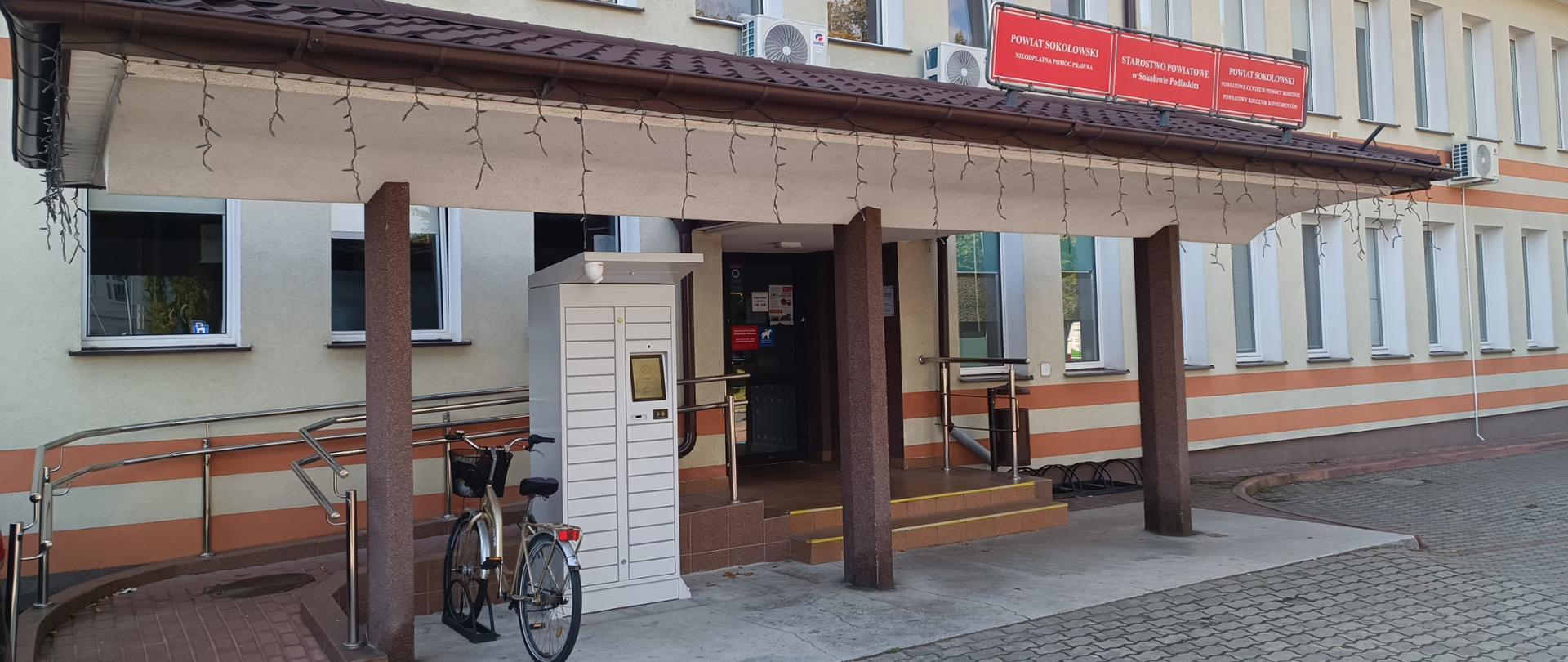 Na zdjęciu budynek Starostwa Powiatowego przy ul. Armii Krajowej 4 w Sokołowie Podlaskim. Widok na wejście przed, którym umieszczony został urzędomat.