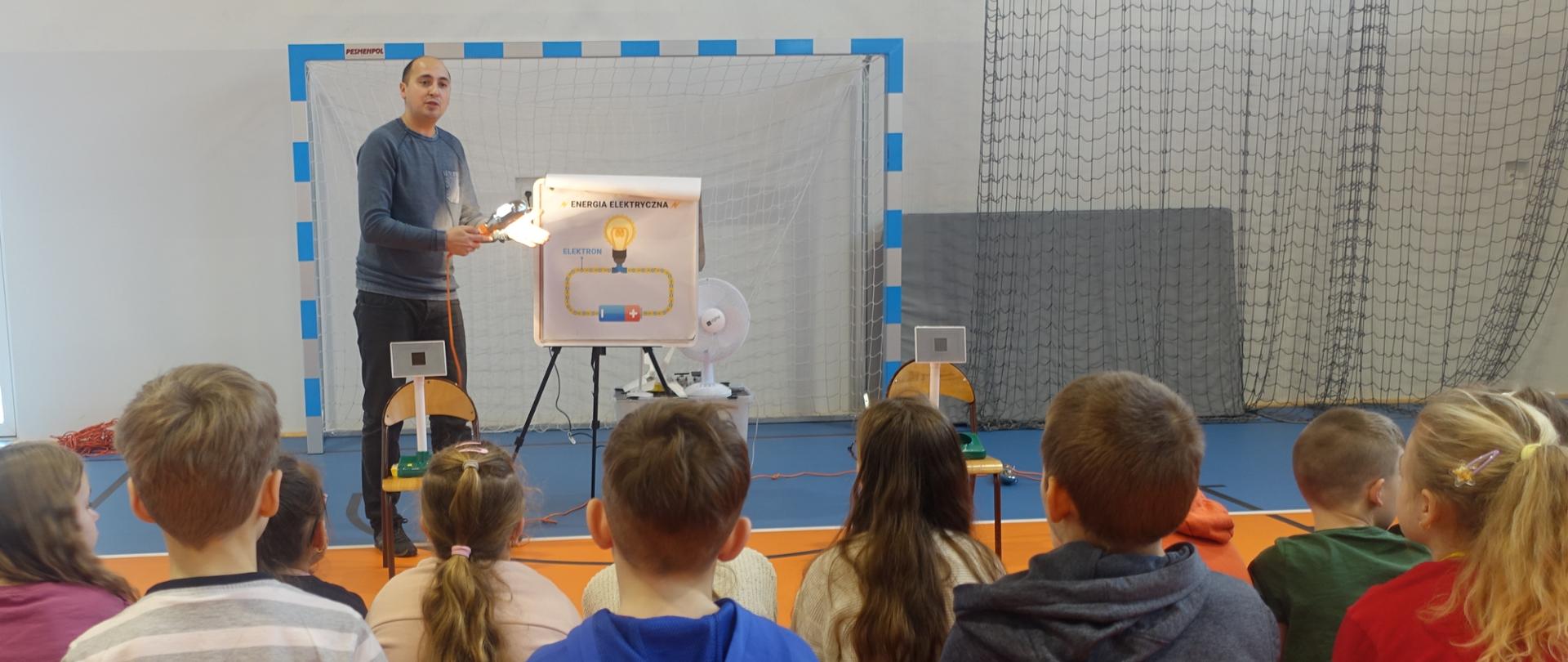 Prowadzący warsztaty edukacyjne „Energia Odnawialna” oraz uczniowie klas II-IV zebrani na sali gimnastycznej