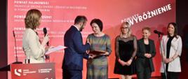 Moment odbioru nagrody przez przedstawicielki samorządu powiatu