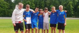 Chłopcy w niebieskich sportowych strojach pozują do zdjęcia