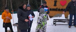 Uczeń odbiera dyplom i nagrodę od pani wójt i wicewójta gminy Łabowa