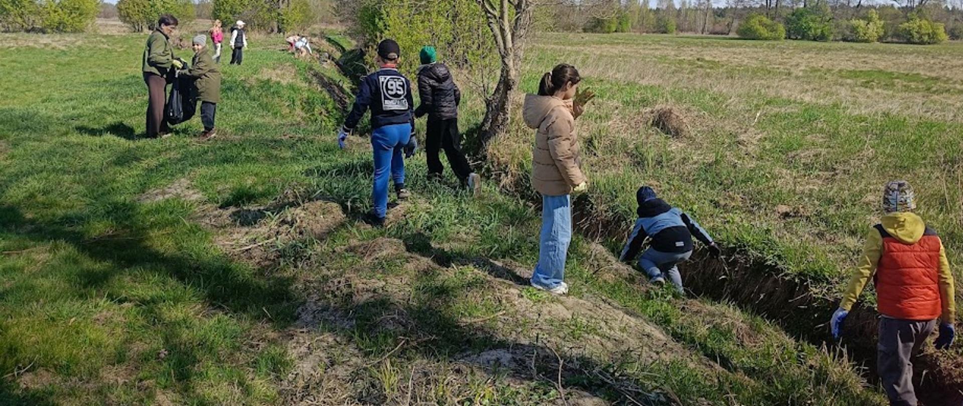 uczniowie zbierają śmieci w ramach akcji czysta rzeka