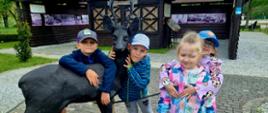 Przedszkolaki pozują do zdjęcia obok figury sarny