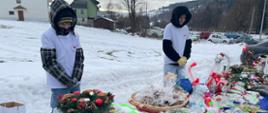 Wolontariusze Szkolnego Koła Wolontariatu sprzedają wykonane przez uczniów ozdoby świąteczne i stroiki oraz przygotowane przez rodziców ciasta