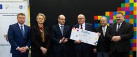 Wójt Gminy Grajewo z symbolicznym czekiem oraz przedstawiciele Urzędu Marszałkowskiego Województwa Podlaskiego