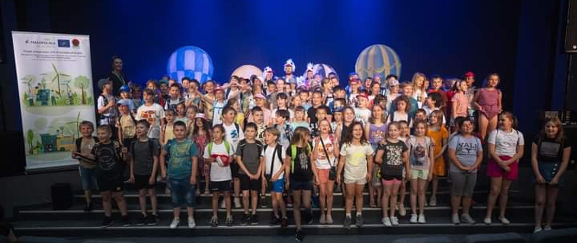 Na zdjęciu uczniowie szkół podstawowych oraz przedszkoli na scenie sali widowiskowej w Centrum Kultury i Wypoczynku w Proszowicach