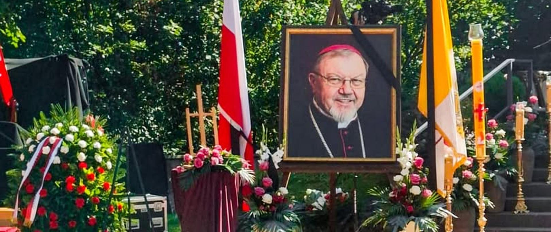 Na fotografii obraz Antoniego Pacyfika Dydycza ustawiony na sztaludze przed ołtarzem plenerowym wśród kwiatów.