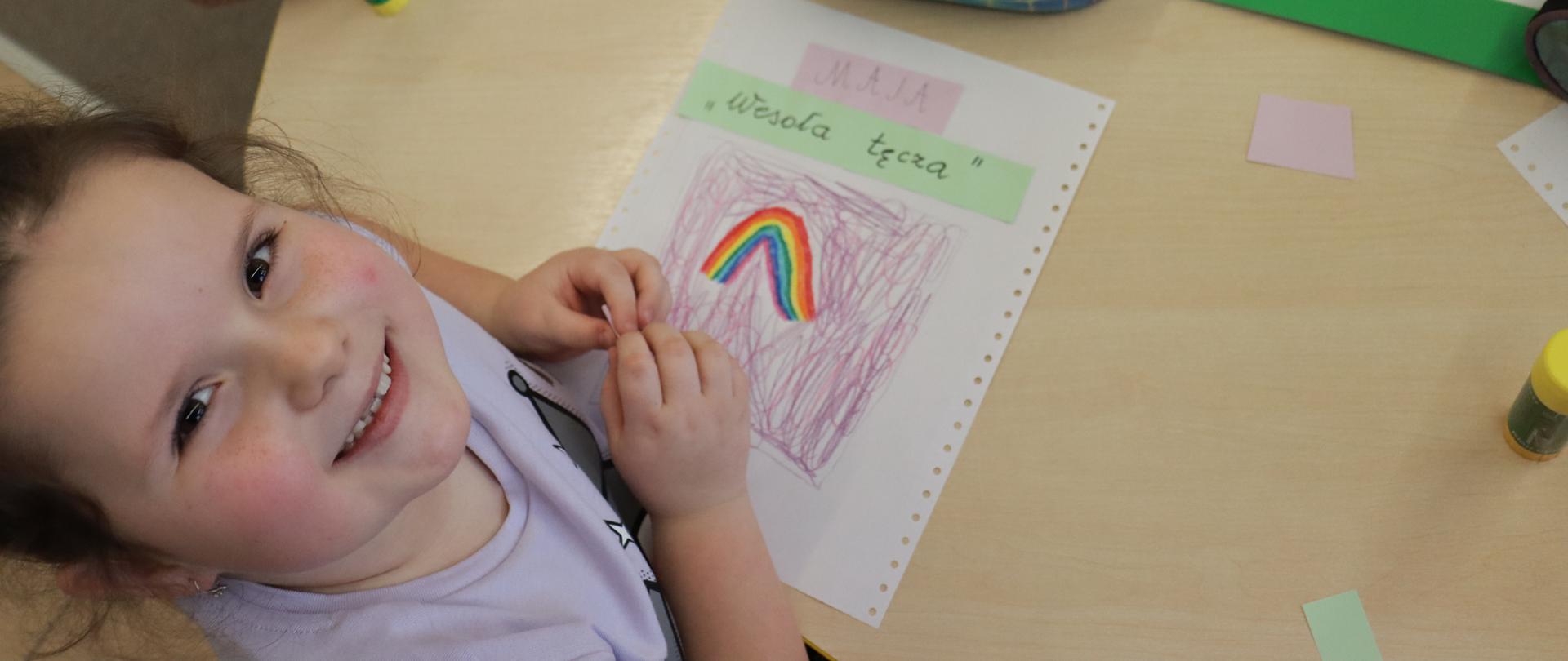 Dziewczynka uśmiechnięta przy stoliku