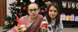 Uczennice przy choince prezentują swoje prace